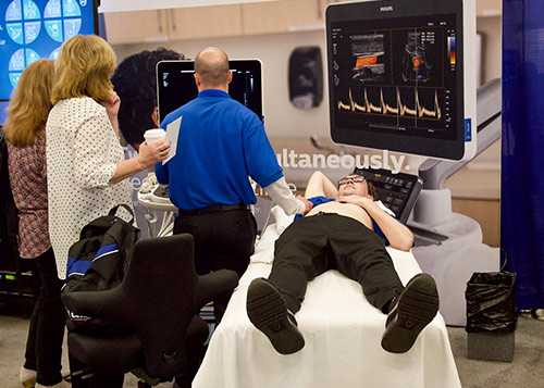 CA man performing an ultrasound with two women watching