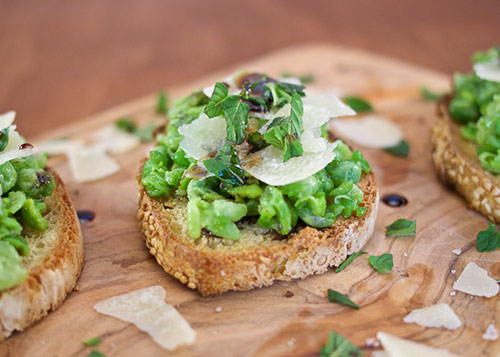 Bruschetta of beans, mint and cheese sitting on a cutting board